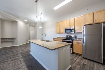 A kitchen with a granite countertop and stainless steel appliances
